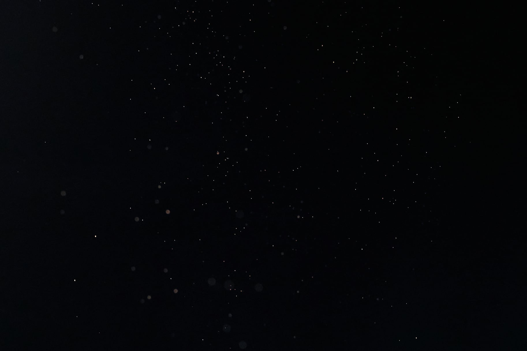 Tiny White Dust Particles on Black Background